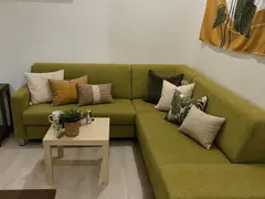 Living room with green corner sofa at Doma Budapest